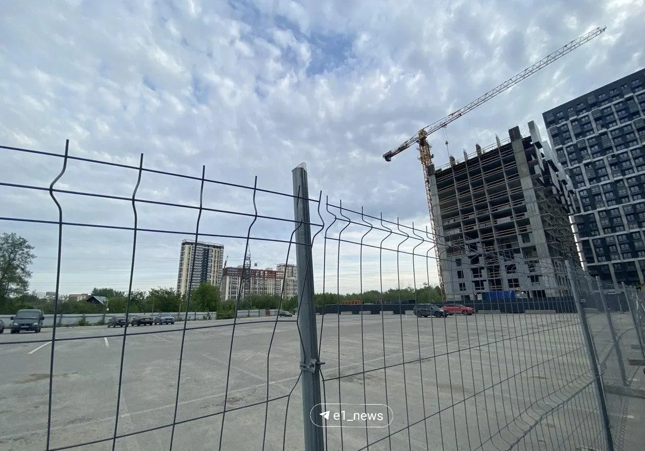 Наземную бесплатную парковку на улице Хуторской оградили для строительства многоуровневого паркинга с платными местами. На время работ жильцам предлагают временную стоянку — мест на ней явно не хватает.