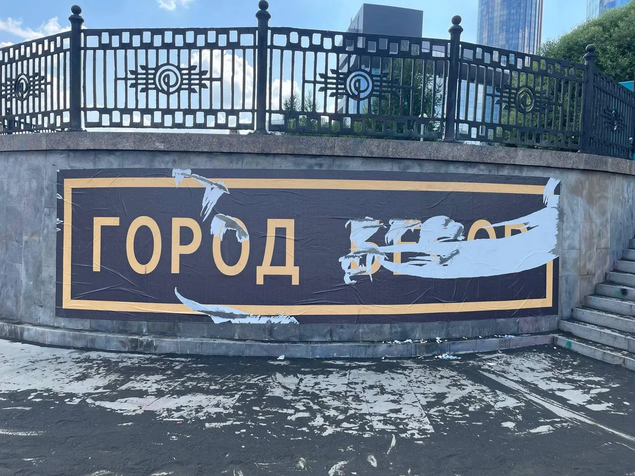 На набережной Исети снова появилась надпись «Город бесов». Авторство установить не удалось — художник Сергей Акрамов отрицает причастность; ранее коммунальщики смыли похожий стрит‑арт, появившийся 1 июля.